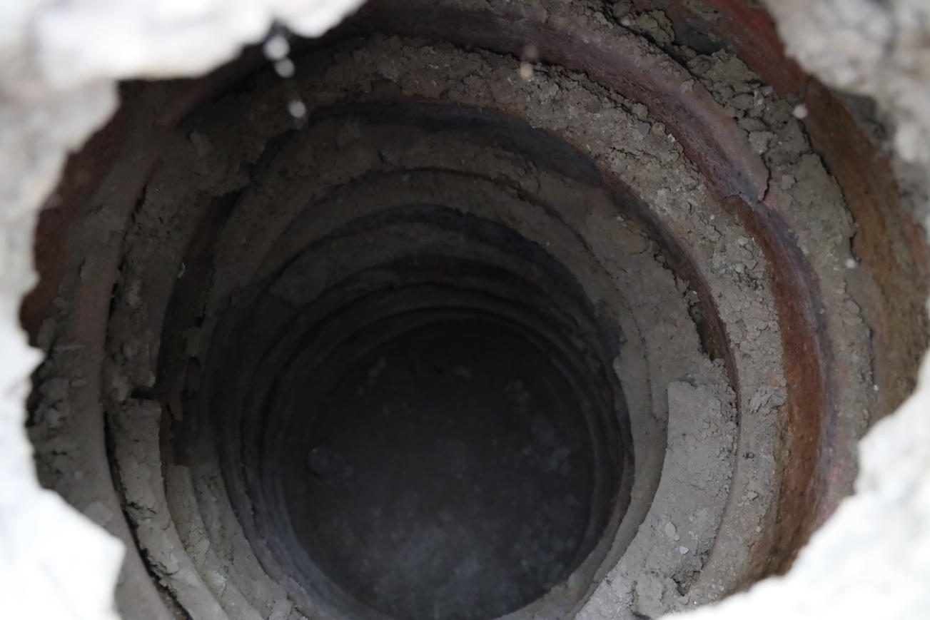 Looking down a terracotta ring-well shaft at Bahaj